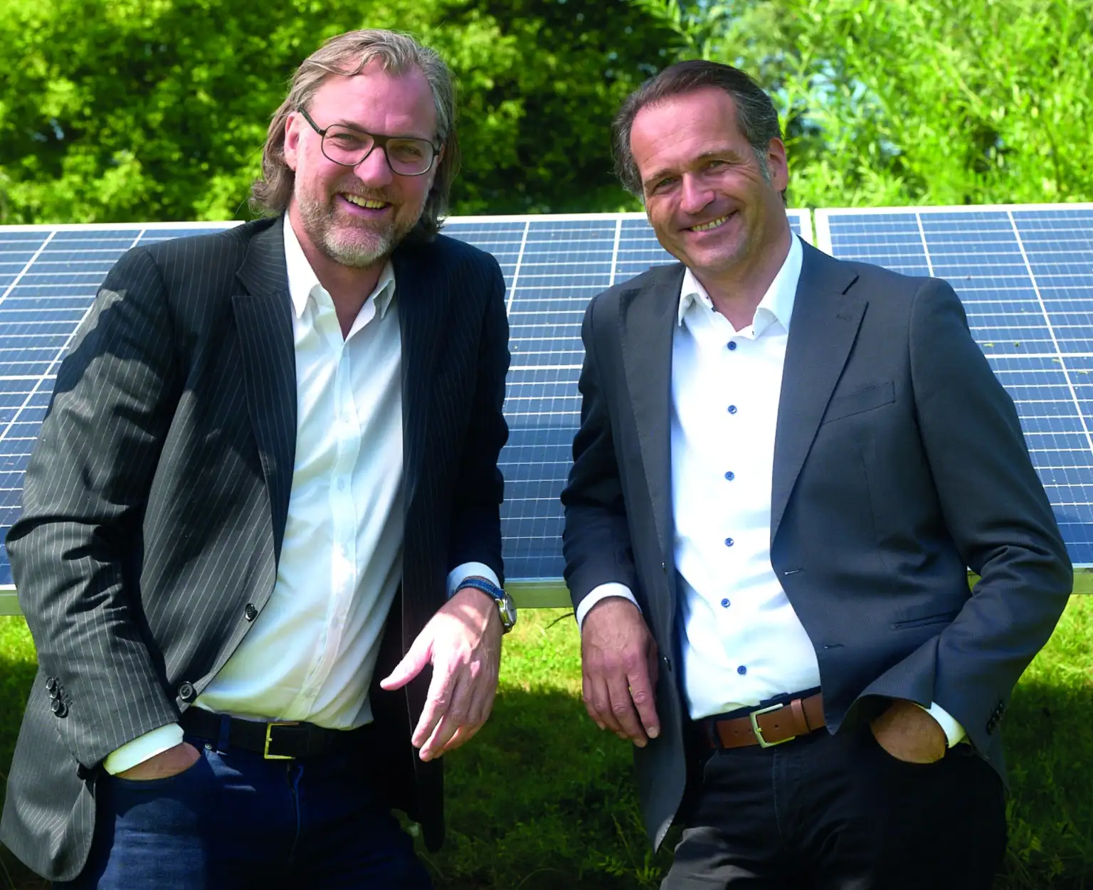 Herr Ofner und Herr Neubauer lehnen an einem Solarpanel