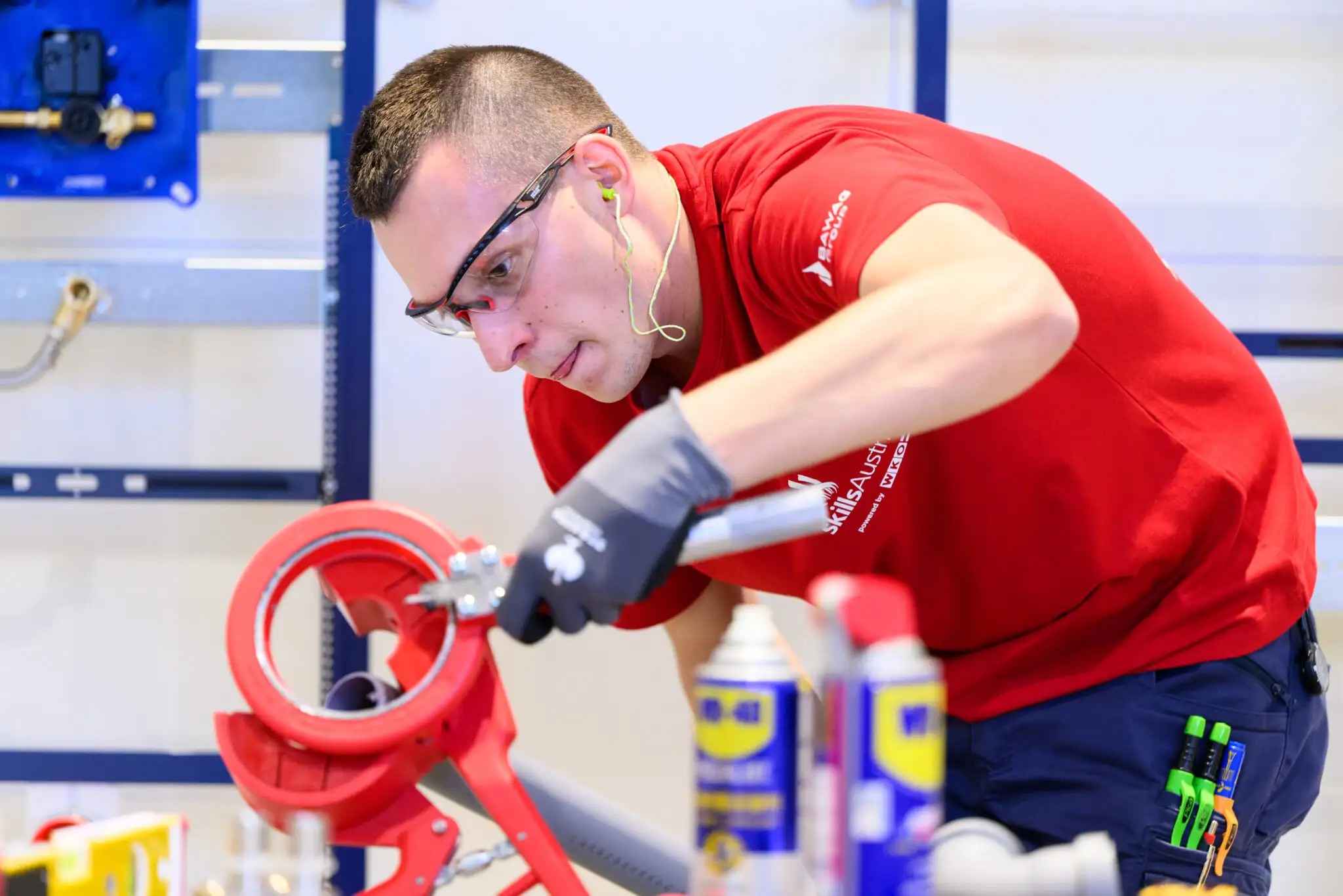 Handwerker mit Schutzbrille und Handschuhen bedient Rotationsschneider in Werkstatt