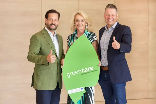 Drei Personen schauen in die Kamera und machen Daumen hoch.